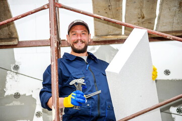 Portrait of confident bricklayer at construction site