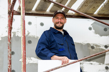 Portrait of confident bricklayer at construction site