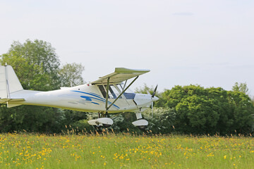 Ultralight airplane landing on a grass strip	