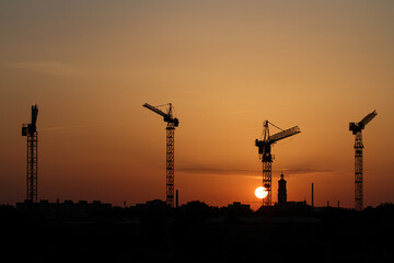 Budowa, Dźwig budowlany na tle zachodzącego słońca.