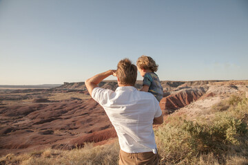 Happy family. Father and son hugging outdoors. Dad with his cute child walking outdoor Adorable curly boy hugging dad. Family Love concept. Summer vacation in American's nation parks Desert background