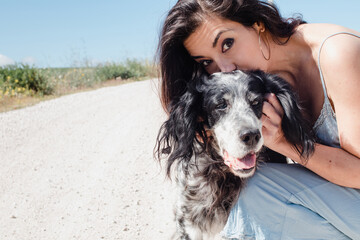 Woman with elderly dog, walking and kissing setter on a summer day with space for text