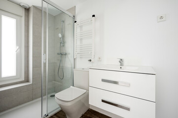 Photo of a bathroom with a bench sink cabinet, a white towel warmer wall radiator