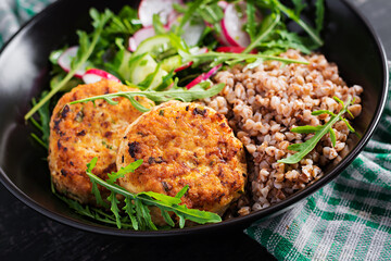 Healthy dinner. Lunch bowl with buckwheat porridge, fried chicken cutlets and fresh vegetable salad of arugula, cucumber and radish.