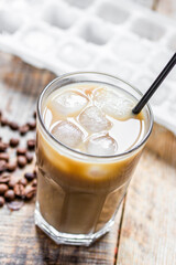 Ice coffee with milk and beans for lunch on wooden background