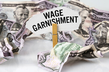 There are dollars on the table and there is a clothespin with paper on which it is written - WAGE...