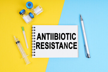 A syringe, ampoules and a notebook with the inscription - ANTIIBIOTIC RESISTANCE