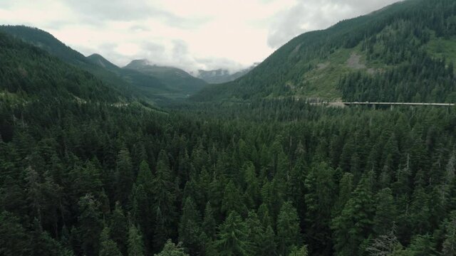 Aerial view over a valley forest and mountain highway