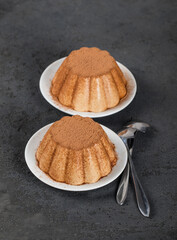 Panna Cotta coffee sprinkled with cocoa powder on a plate on a dark gray background