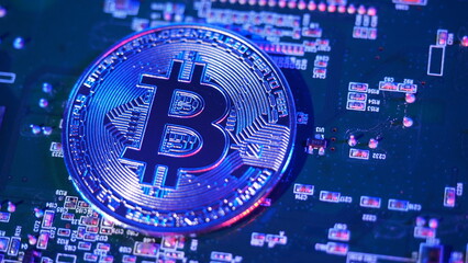 Bitcoin and semiconductor. Represent mining in Cryptocurrency cause global warming. Bitcoins on CPU board. Close-up Bitcoin with blue and pink light. circuit board with coin. Online asset concept. 