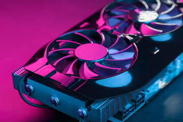 Gaming graphics card with neon magenta-cyan illumination and high-speed fans.