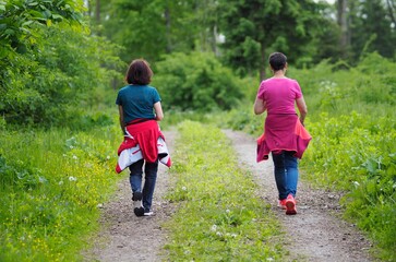 Sportiv - zwei Frauen wandern mit Elan durch den Wald	
