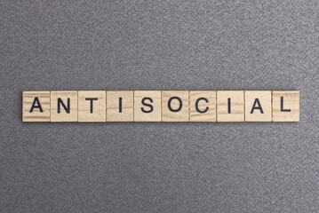 text the word antisocial from wooden small letters with black font on an gray table