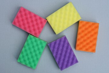 many colored foam sponges lie on a gray table