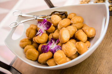 Donut holes in serving bowl with purple flower