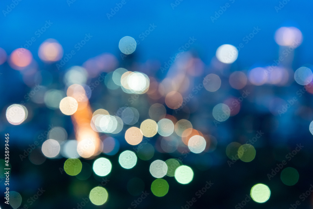 Poster abstract blurred city lights and building with a circular bokeh on blue background.