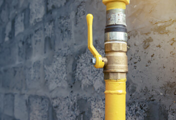 Brass ball valve on gas pipe on grey background
