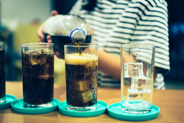 Refreshing Bubbly Soda Pop with Ice Cubes. Cold soda iced drink in a glasses - Selective focus,...