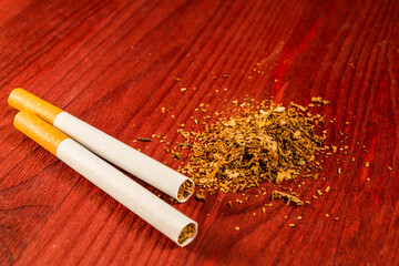Two cigarettes and a fill of tobacco on the table. Close up view