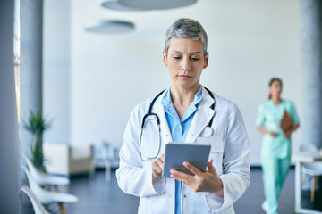 Female doctor working on digital tablet at medical clinic.