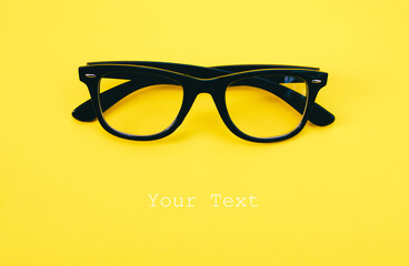 Hipster eyeglasses in black frames on a yellow background. Glasses for vision.