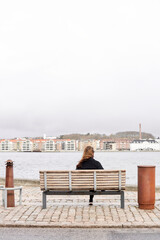 A person sitting on a bench next to a body of water