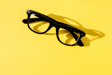 Hipster eyeglasses in black frames on a yellow background. Glasses for vision.