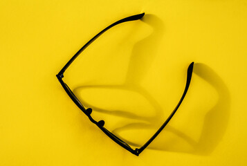 Hipster eyeglasses in black frames on a yellow background. Glasses for vision.