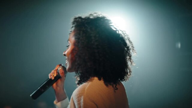 CU HANDHELD Portrait of Black African American young female comedian finishing her stand-up monologue and leaving stage of a small venue. Shot with ARRI Alexa Mini LF with 2x anamorphic lens