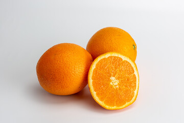whole oranges and half an orange on a white background