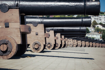 Replica cannons from battleship Goto Pristancia on Admiralteyskaya Square on clear sunny day. Behind cannons located Assumption Admiralty temple.