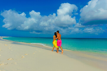 Fototapeta na wymiar Couple at the beach, interracial, running on the sand 