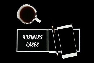 A notebook with black pages, smartphone and a cup of coffee on a black background. The inscription BUSINESS CASES