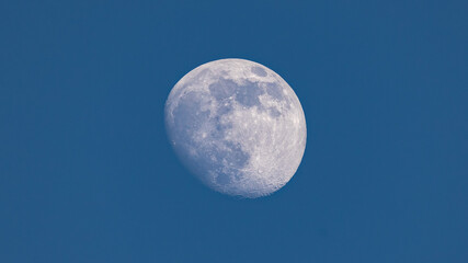Closeup of waxing gibbous moon during daytime against clear blus sky - Stuttgart, Germany May 23,...