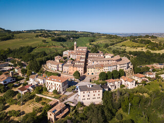 Fototapeta na wymiar Italy, May 2021. Aerial view of the medieval village of Serrungarina in the province of Pesaro and Urbino in the Marche region. You can also see the green hills around.