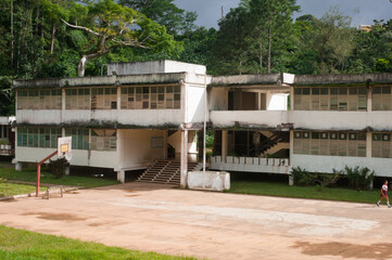 typical elementary panel school on the background of the wild jungle in a state with a planned...