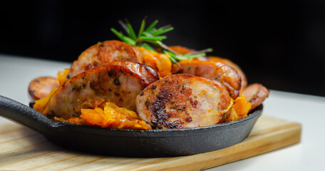 Traditional Polish dish called bigos made of sauerkraut, sausage and mushrooms, food served warm in a cast iron pan