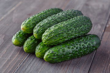 Cucumber on brown wood texture background.Cucumbers harvest in summer. Cucumbers for salads or canning. Summer vegetables. Organic agriculture in village.