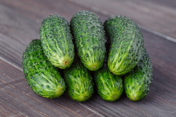 Cucumber on brown wood texture background.Cucumbers harvest in summer. Cucumbers for salads or canning. Summer vegetables. Organic agriculture in village.