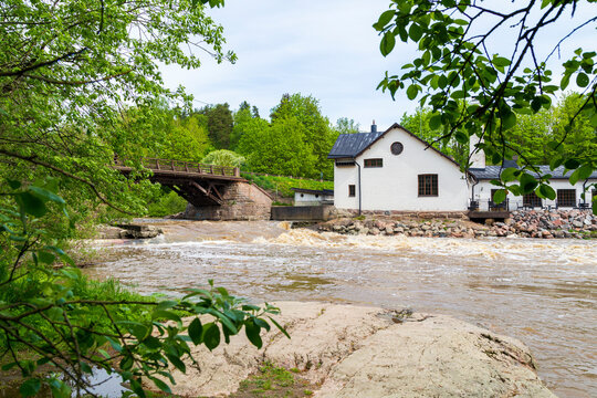 Old bridge and building by the rapid and River Vantaa at the Vantaankoski nature trail in Vantaa, Finland, on a sunny day in the summer.