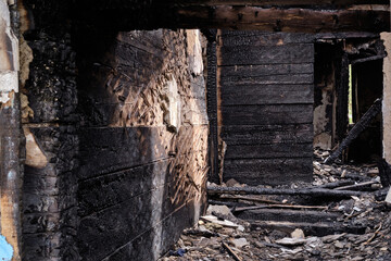 Fototapeta na wymiar Dark burnt wooden house corridor after fire. Building after extinguishing the fire. Ruined house building after a fire