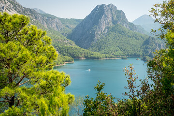 Fototapeta na wymiar Dam lake in Green Canyon. Beatiful View to Taurus Mountains and turquoise water. Coniferous forest with bright green pine trees. Manavgat, Turkey