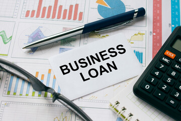 Business card with text Business Loan with, glasses, pen and calculator