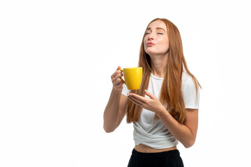 Young beautiful red hair model drinking coffee from yellow mug