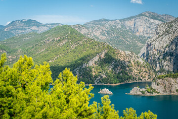 Dam lake in Green Canyon. Beatiful View to Taurus Mountains and turquoise water. Coniferous forest with bright green pine trees. Manavgat, Turkey