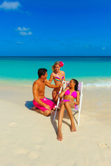 People at the beach, two girls and one guy relaxing, talking, sitting on beach chair, interracial, black
