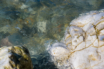 pebble stones on the sea beach, the rolling waves of the sea with foam