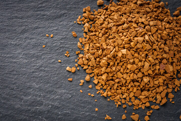 instant coffee granules on a dark stone background