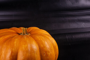 Whole fresh orange big pumpkin on black background, closeup. Organic agricultural product,...
