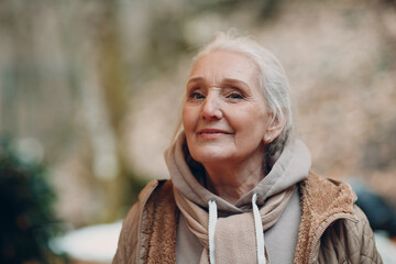 Portrait of smiling gray haired elderly mature woman outdoor